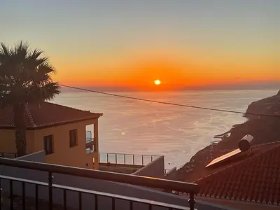 a sunset over the ocean with a house at Beautiful View 2 - Arco da Calheta - Ilha da Madeira in Arco da Calheta