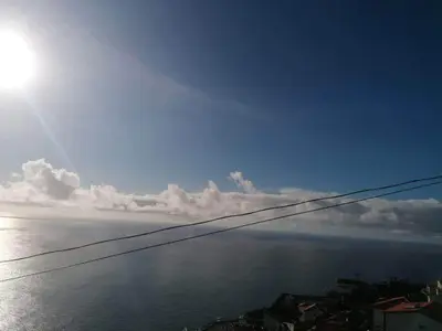a view of the ocean with the sun in the sky at Sunset House in Câmara de Lobos