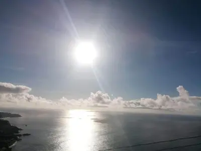 a view of the ocean with the sun in the sky at Sunset House in Câmara de Lobos