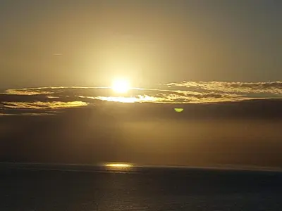 a sunset over the ocean with the sun in the sky at Sunset House in Câmara de Lobos