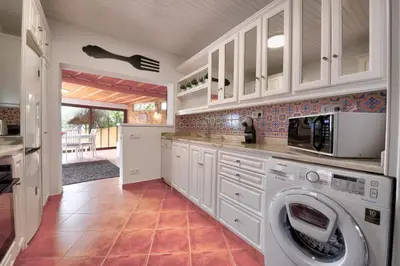 a kitchen with a washing machine and a microwave at The Secret Corner of Luz in Luz