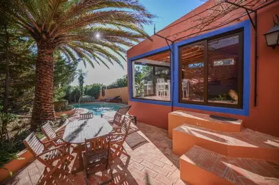 a patio with a table and chairs and a palm tree at The Secret Corner of Luz in Luz