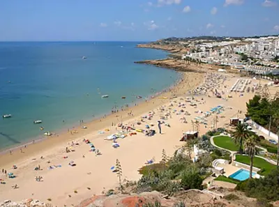 a beach with a lot of people and the ocean at The Secret Corner of Luz in Luz