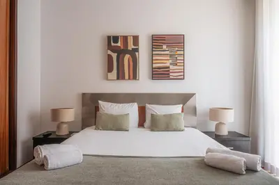 a bedroom with a large white bed with two lamps at Portola Penthouse by YMR in Funchal