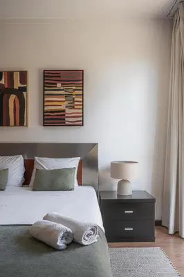 a bedroom with a bed and a lamp on a nightstand at Portola Penthouse by YMR in Funchal