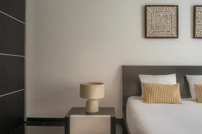a bedroom with a bed and a lamp on a night stand at Portola Penthouse by YMR in Funchal