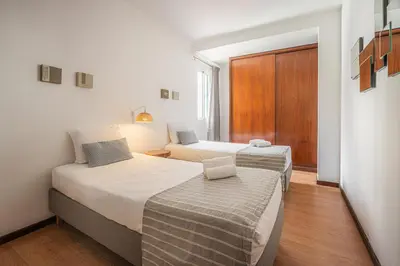 two beds in a small room with a door at Portola Penthouse by YMR in Funchal