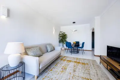 a living room with a couch and a tv at Apartment Henry Matisse, swimming pool in Sagres