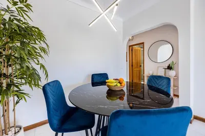 a dining room with a table and blue chairs at Apartment Henry Matisse, swimming pool in Sagres