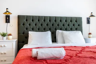 a bedroom with a red bed with a green headboard at Apartment Henry Matisse, swimming pool in Sagres