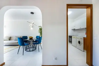 a kitchen and dining room with a table and blue chairs at Apartment Henry Matisse, swimming pool in Sagres