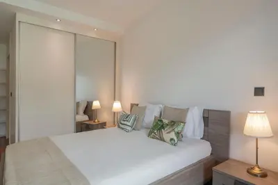 a bedroom with a large white bed with two lamps at Madalenas XXI by An Island Apart in Funchal