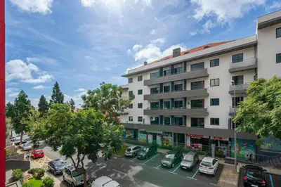 an apartment building with cars parked in a parking lot at Madalenas XXI by An Island Apart in Funchal