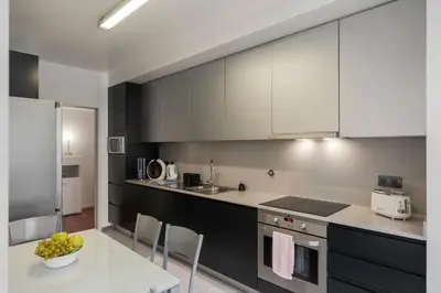 a kitchen with black and white cabinets and a table at Madalenas XXI by An Island Apart in Funchal