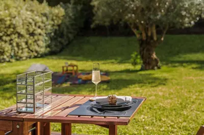 a table with a glass of wine and a plate of food at Savoy Residence Casa Branca I by An Island Apart in Funchal