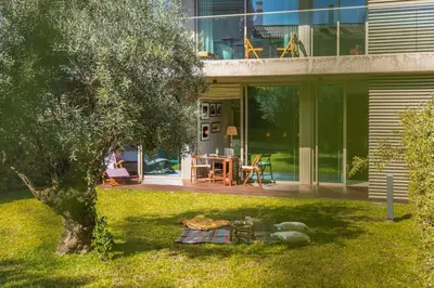 a teddy bear laying in the grass next to a house at Savoy Residence Casa Branca I by An Island Apart in Funchal