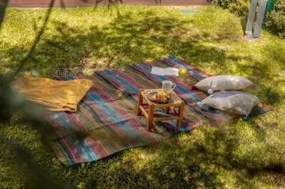a picnic blanket on the grass with a table at Savoy Residence Casa Branca I by An Island Apart in Funchal