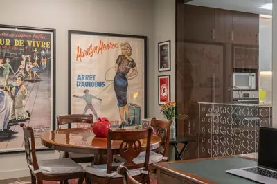 a dining room with a table and chairs and posters at Savoy Residence Casa Branca I by An Island Apart in Funchal