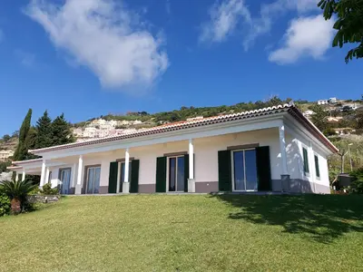 a white house with a green lawn in front of it at Neves by BCA Villas in Funchal