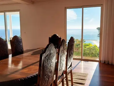 a dining room with a table and views of the ocean at Neves by BCA Villas in Funchal