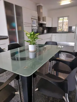 a kitchen with a glass table with chairs and a plant at Neves by BCA Villas in Funchal