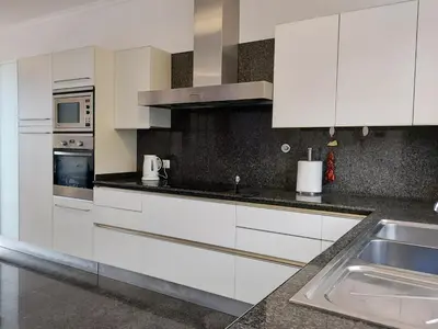 a kitchen with white cabinets and a sink at Neves by BCA Villas in Funchal