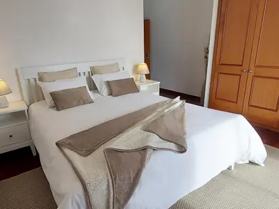 a large white bed in a room with two lamps at Neves by BCA Villas in Funchal