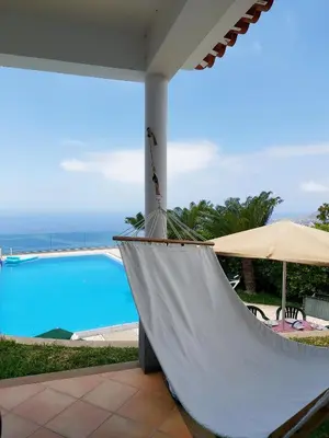 a hammock in front of a swimming pool at Neves by BCA Villas in Funchal