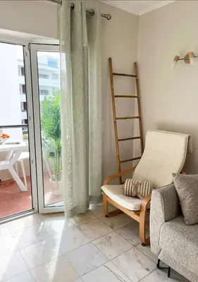 a living room with a chair and a sliding glass door at Lagos Apartment Sea View in Lagos
