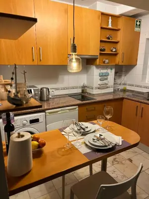 a kitchen with a wooden table with wine glasses at Lagos Apartment Sea View in Lagos