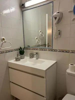 a bathroom with a sink and a mirror and a toilet at Lagos Apartment Sea View in Lagos