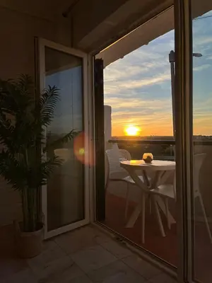 a balcony with a table and a view of the sunset at Lagos Apartment Sea View in Lagos