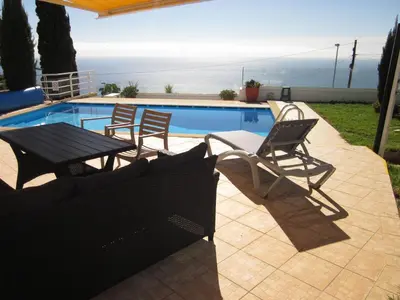 a patio with a table and chairs next to a pool at Villa Hansen in Garajau - Cristo Rei in Caniço