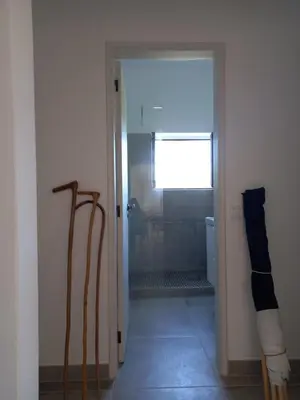 a bathroom with a shower and a glass door at Tasi Ingrina in Vila do Bispo