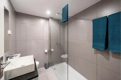 a bathroom with a sink and a shower with blue towels at Atlantic Blue 1 - central and with garage in Funchal