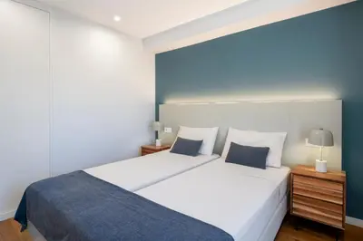 a bedroom with a large white bed with blue walls at Atlantic Blue 1 - central and with garage in Funchal