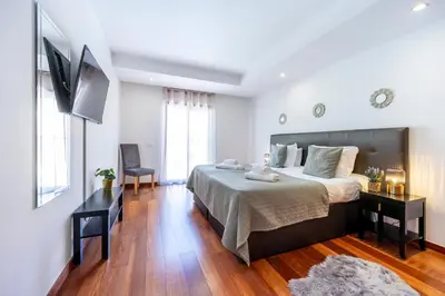 a balcony with two chairs and a table and a large window at Baia da Luz - Tropicana Beach Apartment in Luz