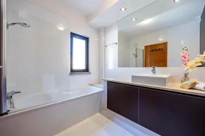 a bathroom with a tub and a sink and a bath tub at Baia da Luz - Tropicana Beach Apartment in Luz