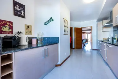 a bedroom with a large bed and a large window at Baia da Luz - Tropicana Beach Apartment in Luz