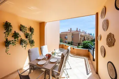 a yellow and white church with a clock tower at Baia da Luz - Tropicana Beach Apartment in Luz