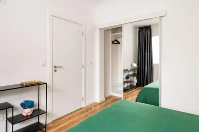 a bedroom with a mirror and a green rug at Eva Boutique Apartment in Funchal