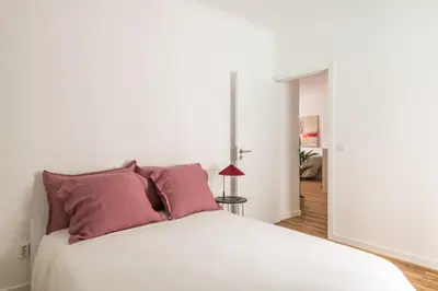 a bedroom with a white bed with purple pillows at Eva Boutique Apartment in Funchal