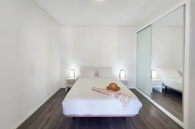 a white bedroom with a bed and a mirror at Oásis by BCA Villas in Porto Santo