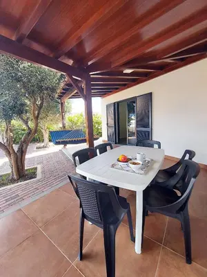 a dining room with a white table and chairs at Oásis by BCA Villas in Porto Santo