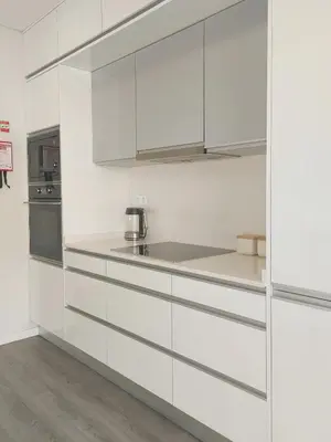 a white kitchen with white cabinets and a stove at Oásis by BCA Villas in Porto Santo