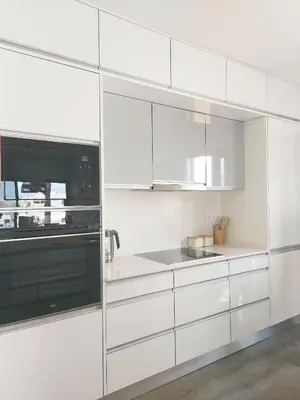 a white kitchen with white cabinets and a microwave at Oásis by BCA Villas in Porto Santo