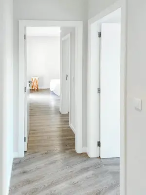 an empty room with white walls and wood floors at Oásis by BCA Villas in Porto Santo