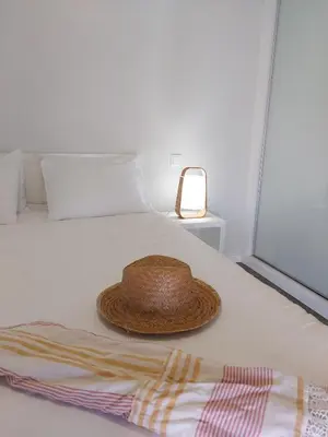 a straw hat sitting on top of a bed at Oásis by BCA Villas in Porto Santo