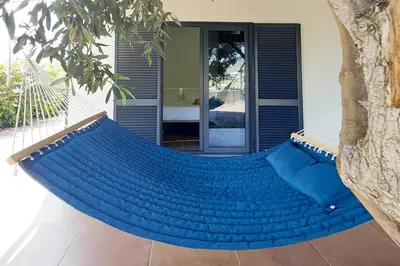 a blue hammock in front of a house at Oásis by BCA Villas in Porto Santo