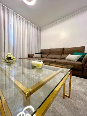 a living room with a glass table and green chairs at Funchal Lido View 1 in Funchal